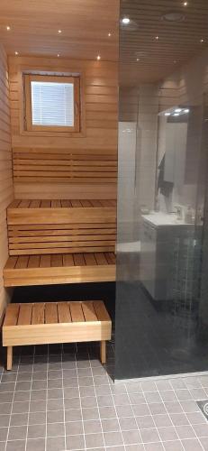 Habitación con sauna con lavabo y espejo. en Pikiruukin helmi, en Kokkola