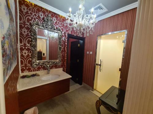 ein Bad mit einem Waschbecken und einem Spiegel in der Unterkunft Botanical Garden Vacation House in Liwa