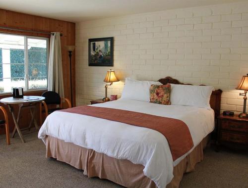 1 dormitorio con 1 cama grande y 1 mesa en Back Bay Inn en San Luis Obispo