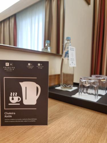 a box on a table with a bottle and glasses at Hotel Principe Lisboa in Lisbon