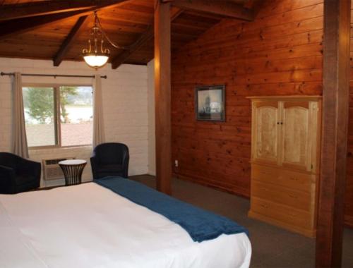 a bedroom with a large bed in a room with wooden walls at Back Bay Inn in San Luis Obispo