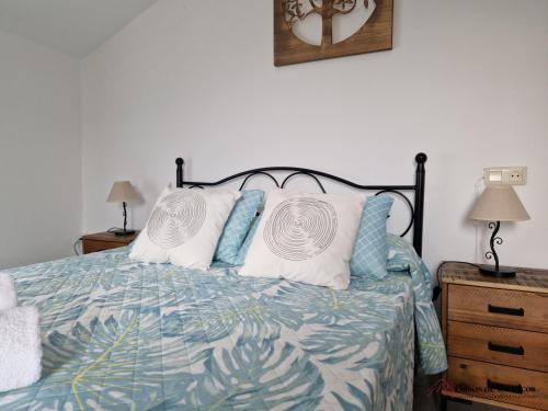 a bedroom with a bed with a blue and white comforter at Vivienda Vacacional La Escribana - Casas de los Picos in El Mazo