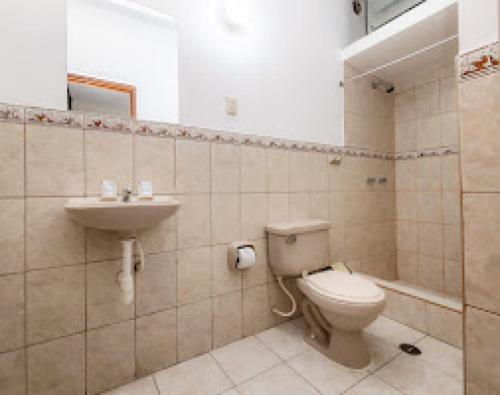 a bathroom with a toilet and a sink at Hotel Santa Lucia - Oficial in Piura