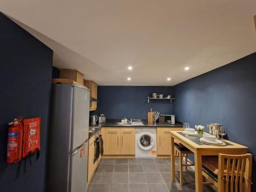 a kitchen with a refrigerator and a table with chairs at Digbeth Apartment Sleeps 5 in Birmingham