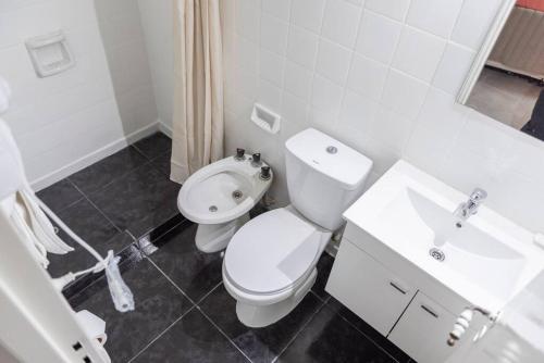 Un baño blanco con inodoro y lavabo. en Cañitas Chic, en Buenos Aires