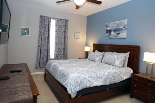 um quarto com uma cama com paredes azuis e uma janela em WH205B 3 BR Windsor Hills Condo! em Orlando