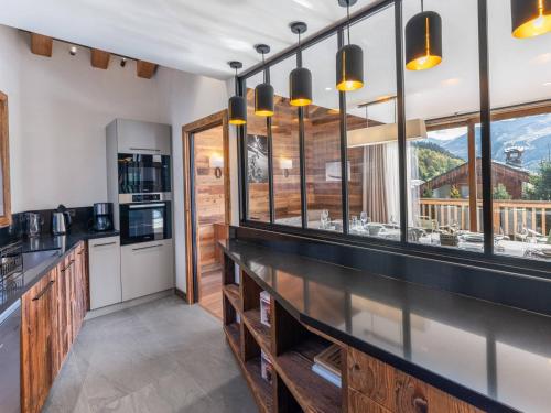 - une cuisine avec un comptoir et quelques fenêtres dans l'établissement Chalet moderne lumineux proche pistes - 12 pers, 5 ch, parking, wifi, ménage inclus - FR-1-566-43, à Les Allues