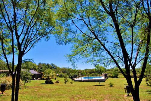 una piscina en medio de un parque con árboles en Keantúpa Cabañas en San Marcos Sierras