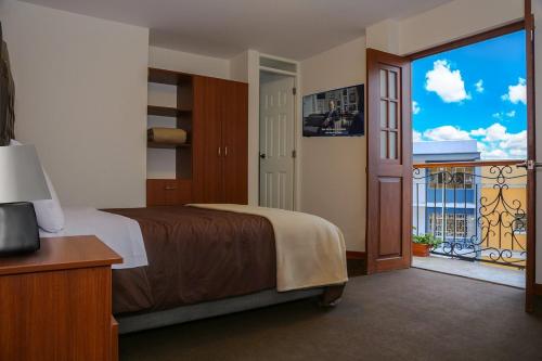 特魯希略的住宿－REAL MARQUEZ，一间带大床的卧室和一个阳台