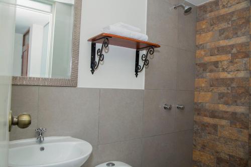 y baño con lavabo, aseo y espejo. en REAL MARQUEZ, en Trujillo