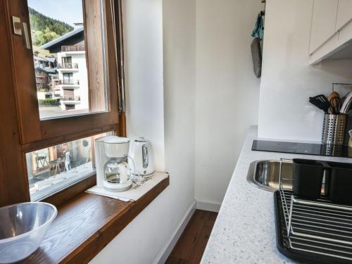 - un comptoir de cuisine avec une fenêtre à côté d'un évier dans l'établissement Studio Cabine Rénové Centre Village - 28m² - Balcon - 3 Pers - Parking - Les Gets - FR-1-685-9, aux Gets