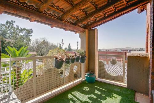 a balcony with green grass and potted plants on it at Paulshof Guesthouse - Monchique in Sandown