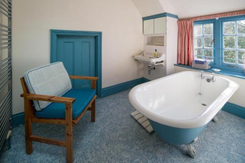 y baño con bañera, silla y silla. en Bay House, en Seaview