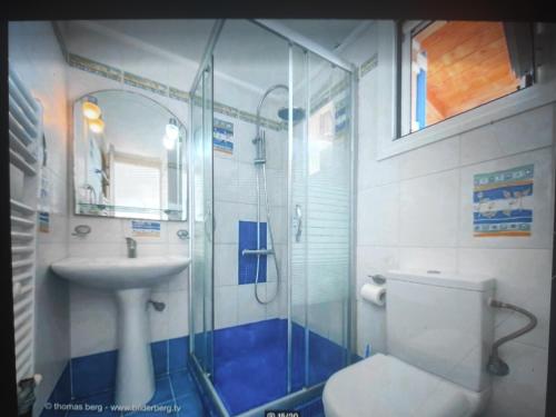 a bathroom with a shower and a toilet and a sink at Tapia Hills in Methoni