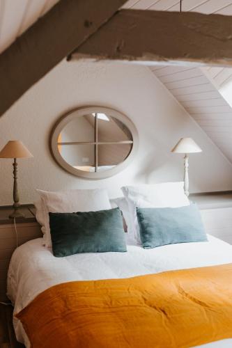 a bedroom with a bed with two blue pillows at Gîtes du Bulz, en pleine forêt proche de la mer in Pleyber-Christ