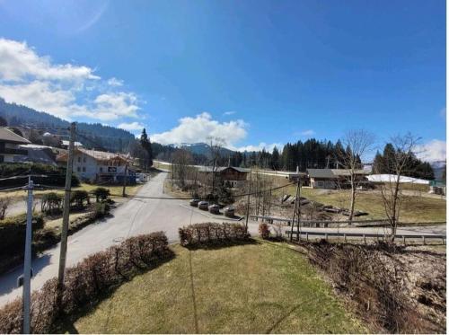 an empty street in a small town with a mountain at Appartement le StelO Les Gets 6 personnes aux pieds des pistes 2 chambres in Les Gets