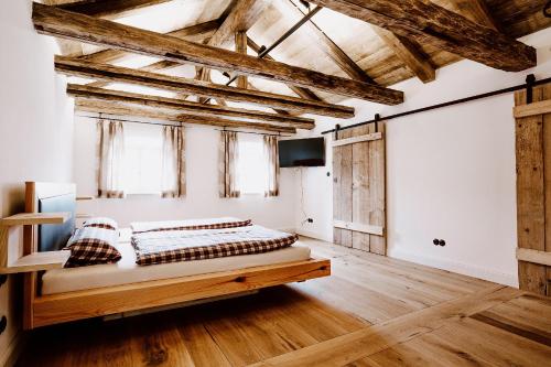 1 dormitorio con 1 cama en una habitación con techos de madera en Jura-Chalet, en Riedenburg