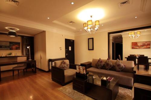 a living room with a couch and a dining room at Boudl Kuwait Al Fahahil in Kuwait