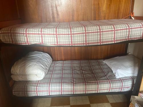 two bunk beds in a room with a plaid bedsheet at l'montagne 1650 in Courchevel