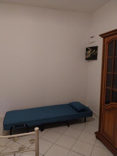 a blue bench sitting in a corner of a room at Cocon calme, 2 pièces Tours proche bord de Loire in Tours