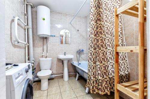 een badkamer met een wastafel en een douchegordijn bij Квартира в престижном районе в новостройке in Pavlodar