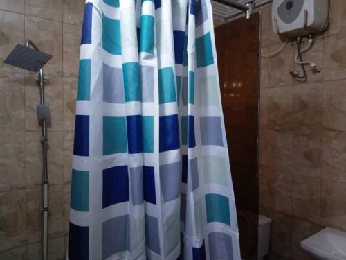 a bathroom with a shower curtain in a bathroom at Ritz & Gold Hotel & Suites, Makurdi in Makurdu