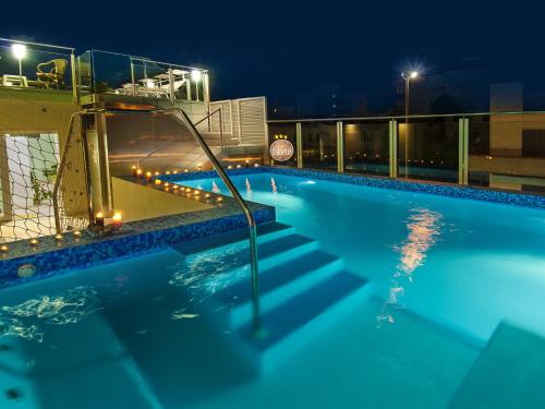 a swimming pool at night with the lights on at Hotel Bahamas in Lido di Savio