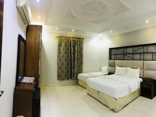 a hotel room with two beds and a telephone at راسيات الحمدانية - Hotel Rasiyat in Jeddah