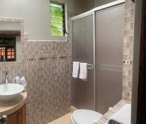 een badkamer met een douche, een toilet en een wastafel bij Habitacion en Casa de Campo, Valle Sagrado de los Incas in La Planicie
