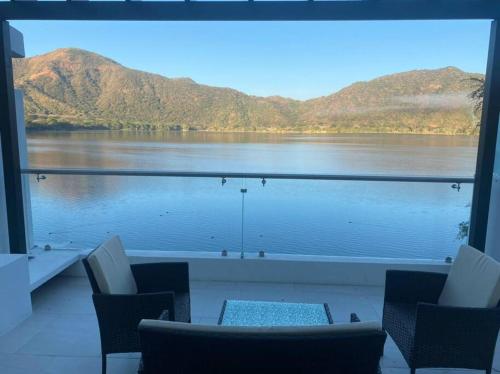 a view of a lake from a room with chairs at Casa Blanca SAMAO in Chichicasta