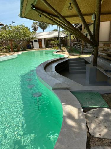 a swimming pool with green water in a house at Apartamento no Condominio Amaré in Barra Grande