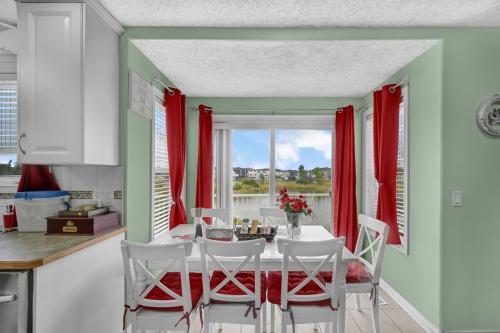 comedor con cortinas rojas, mesa y sillas en 48a Luxury Lake Home W Massage Meditation Gym Ac, en Calgary