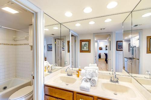 a bathroom with two sinks and a tub and a toilet at Ocean Vista #1101 in South Padre Island