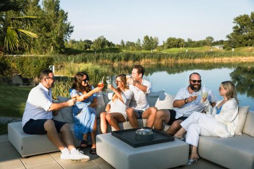 a group of people sitting on a couch drinking wine at Hotel Diamond Country Club in Atzenbrugg