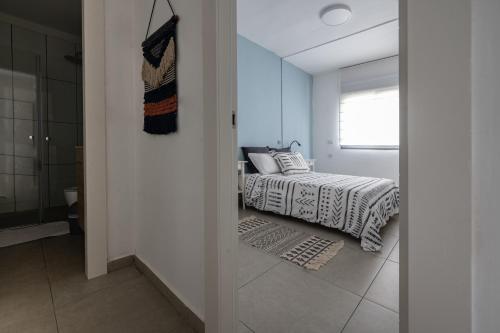a bedroom with a bed and a window and a bathroom at Family Apartment By IsrApart in Ramat Gan