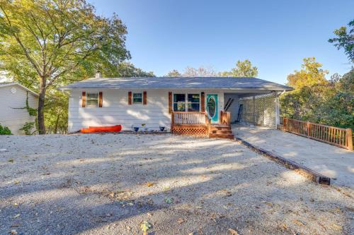 a white house with a porch and a driveway at Lakefront Gem with Screened Porch and Game Room! in Shell Knob