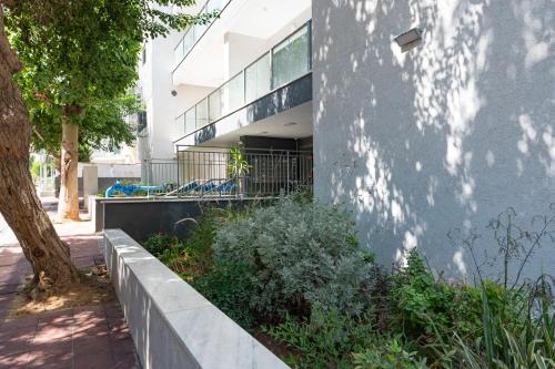 a building with a garden in front of it at Family Apartment By IsrApart in Ramat Gan