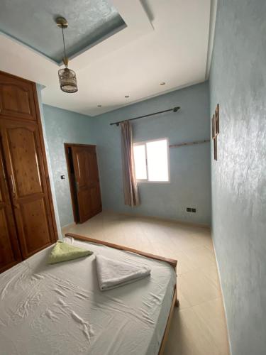 a bedroom with a bed in a room with a window at Atlas Surf Morocco in Tamraght Ouzdar