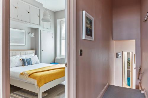 ein kleines Schlafzimmer mit einem Bett und einem Flur in der Unterkunft Spacious beach front apartment with stunning sea views in Deal