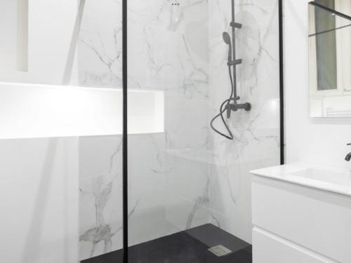 une salle de bain blanche avec une douche et un lavabo dans l'établissement Village Vauban Suite, à Marseille