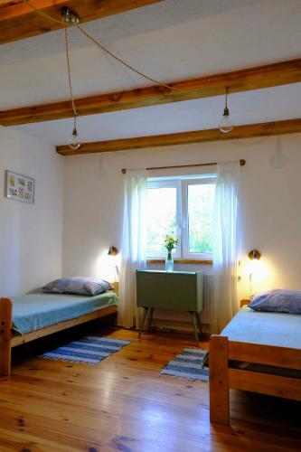 a bedroom with two beds and a window and a desk at Agroturystyka TWÓJ KĄCIK in Kurzętnik
