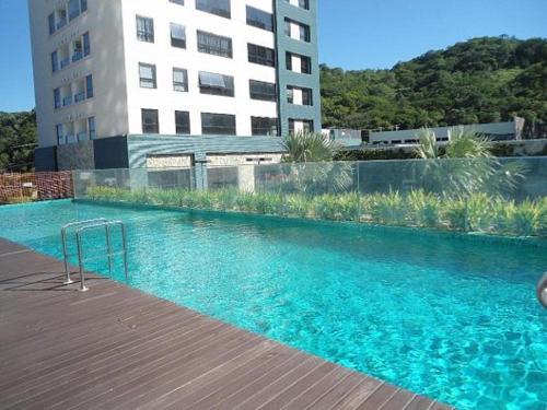 uma grande piscina azul ao lado de um edifício em SUPER Conforto Praia Brava Balneario Camboriu em Itajaí