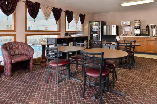 a restaurant with tables and chairs and a kitchen at America's Best Value Inn Beardstown in Beardstown