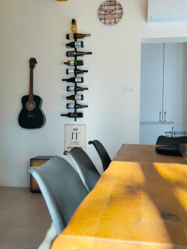 a room with a wooden table and a guitar on the wall at Casa Mido Badacsony in Badacsonytomaj