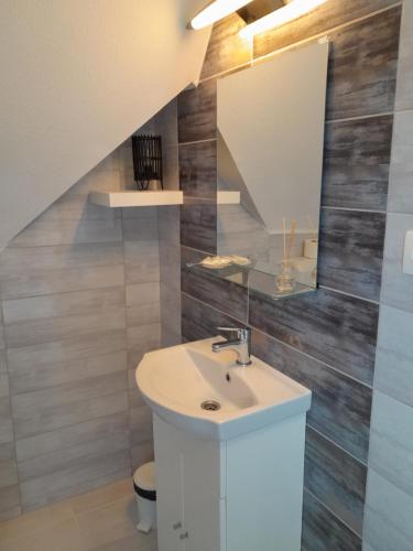 a bathroom with a sink and a mirror at Béke Stúdió Apartman in Fonyód