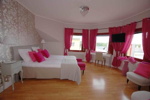 a bedroom with a white bed with red pillows at Avesta Stadshotell in Avesta