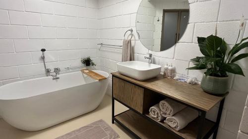 a bathroom with a tub and a sink and a mirror at Thatchwood Cottage in Hilton
