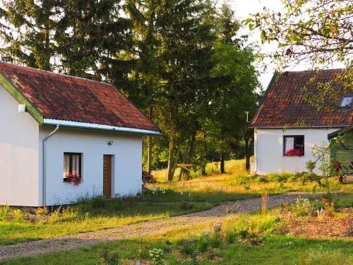 ein weißes Haus mit rotem Dach und zwei Gebäuden in der Unterkunft Po Prostu Dobro in Mrągowo