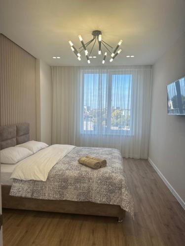 - une chambre avec un grand lit et une fenêtre dans l'établissement LUX Apartment Av.Iancu floor6, à Chişinău