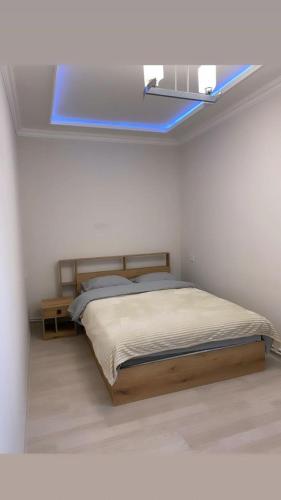 1 dormitorio con cama y ventana azul en Lidiani Guest House en Gyumri